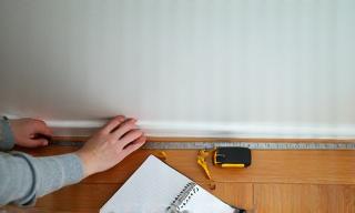 Person measuring a living room floor